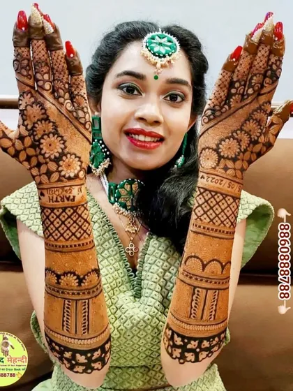 A happy bride beautifully dressed and showing off her intricate back-of-hand mehndi. We love capturing these moments of joy.