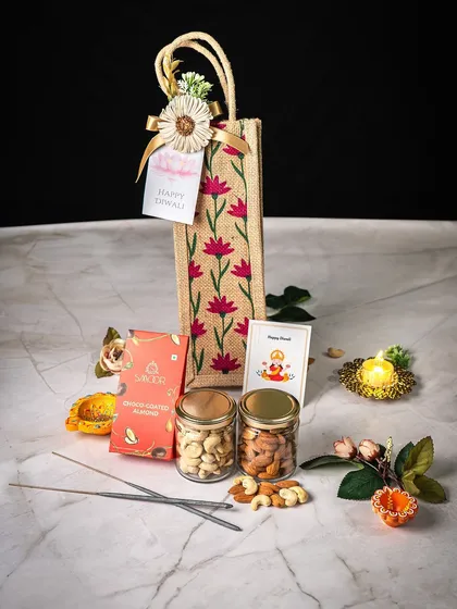 This elegant Diwali hamper is one of our signature festive offerings. It features a custom-printed jute bag containing premium assorted dry fruits in glass jars, artisanal chocolates, and traditional items like a decorative diya and incense sticks. We design these to be a complete, thoughtful gift for the festival of lights.