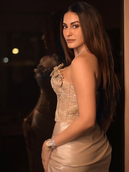 A profile shot of Amyra Dastur against a dark background, with her reflection visible. This adds depth and a touch of mystery to the portrait.