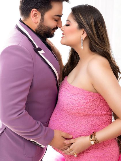 An intimate and stylish maternity portrait. The vibrant pink and purple outfits create a look that is both modern and romantic.