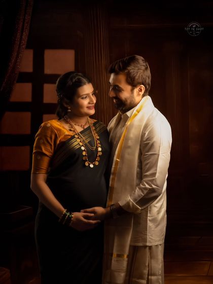 An intimate couple's portrait in traditional attire, captured in a low-key setting that emphasizes their connection.