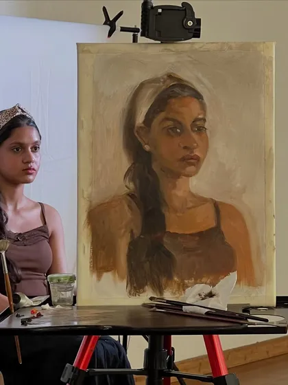 Here is the portrait of Simran on the easel next to her. This helps show the scale of the 9x12 oil on linen painting and the setup for our live session.