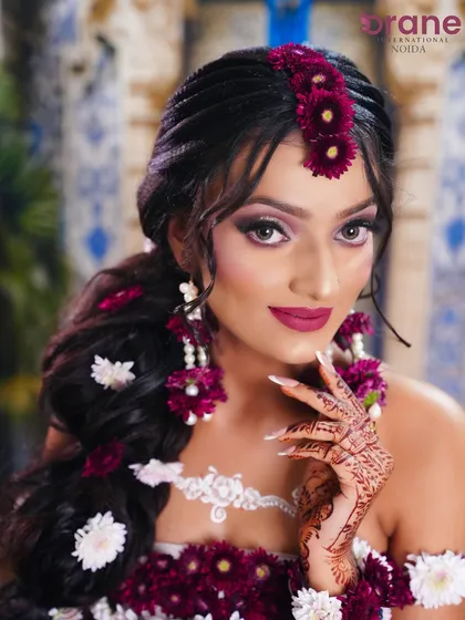 This close-up highlights the intricate floral jewelry and the bold magenta lip, which complements the flowers perfectly.