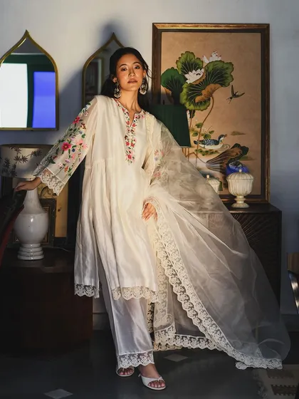 An elegant full-length portrait for the brand Baavli. The composition highlights the flow of the fabric and the intricate embroidery of this beautiful white ensemble.