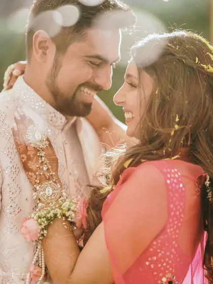 A happy, sun-kissed portrait of the couple, their smiles radiating pure happiness. The backlighting adds a warm, romantic glow to the image.