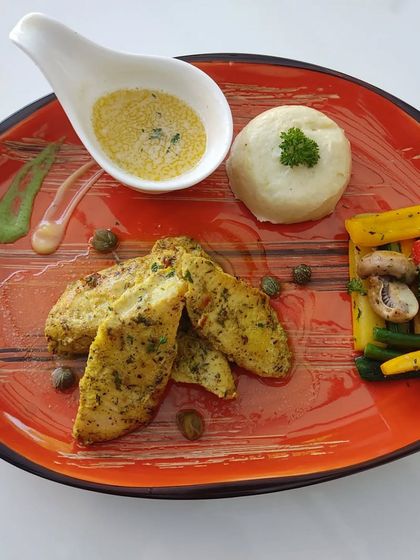 A complete and balanced meal option from our healthy menu. This plate features herb-grilled chicken, mashed potatoes, and a side of sautéed vegetables like bell peppers, broccoli, and mushrooms.