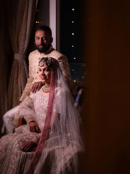 A classic, elegant portrait of the bride and groom at their reception. This posed shot is a beautiful, formal record of their special day, showcasing their wedding attire.