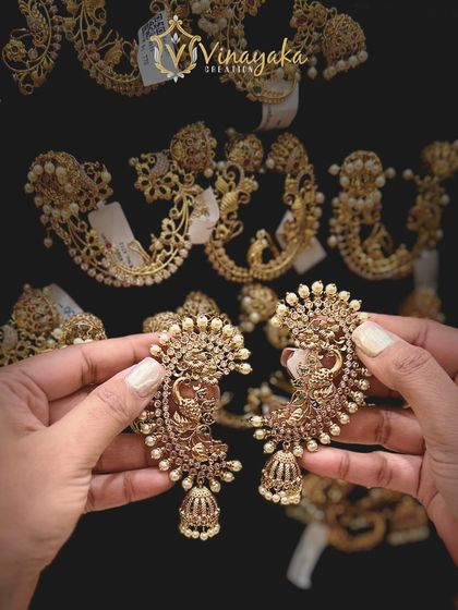 These grand earcuffs have a Ganpati motif with pearl detailing and a large jhumka drop. They are perfect for festive occasions.