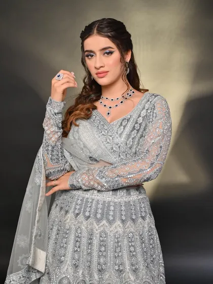 Another look at the elegant grey lehenga, paired with a sapphire necklace to add a pop of color. It's a versatile piece that can be styled in many ways.
