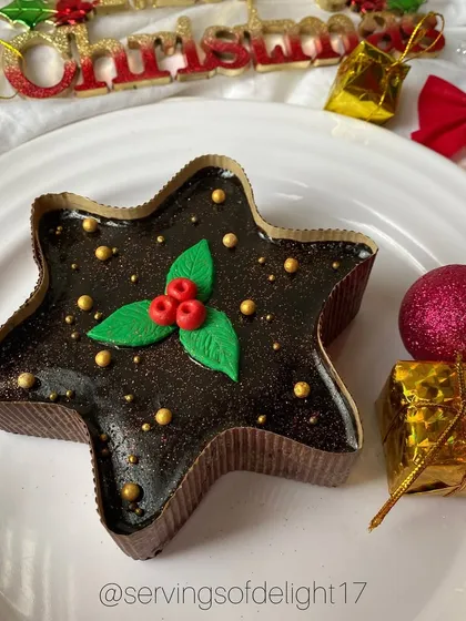 Jingle all the way with this star-shaped Christmas cake. It's a rich chocolate cake decorated with a fondant holly, perfect for your holiday table.