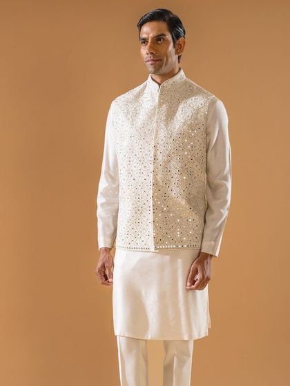 This ivory Jawahar jacket is adorned with intricate threadwork and shimmering mirror details. It is the epitome of grace for the spring season, perfect for adding a touch of sparkle to your ensemble.