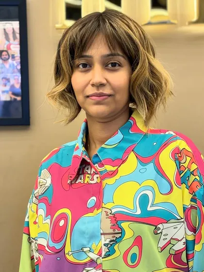 A frontal view of a client's creative cut and color. The look is modern, edgy, and perfectly suits her vibrant personality.