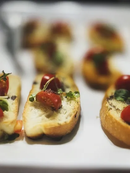 A classic Italian starter, my bruschetta features crisp toasted bread topped with fresh cherry tomatoes, herbs, and a drizzle of balsamic glaze. It's a simple, fresh, and always popular choice.