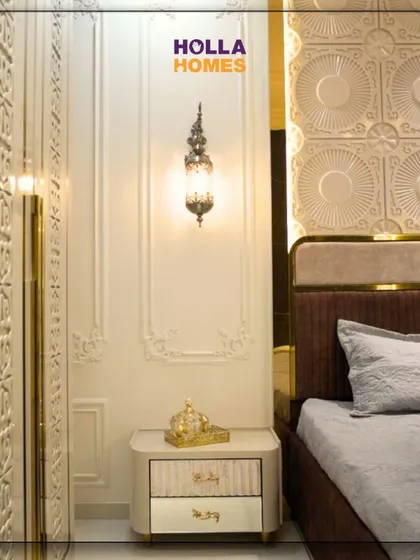 A close-up of the bedside in the Parisian master bedroom. The ornate wall sconce and custom nightstand with classic design elements contribute to the room's overall theme of timeless elegance.