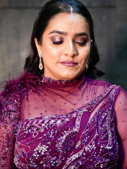 Serving glam with this beautiful purple outfit. The makeup features a dramatic smokey eye with purple tones and a flawless base.