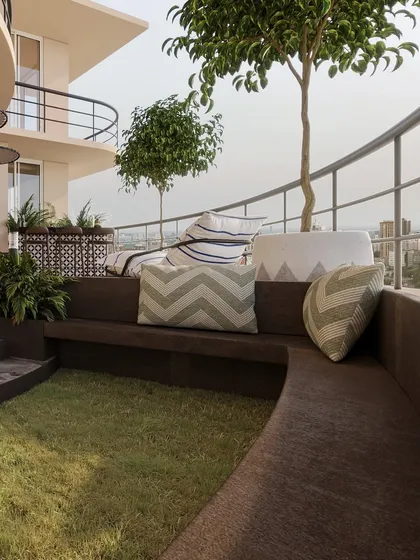 A built-in curved bench with a central grass patch creates a unique and cozy seating area, blurring the line between architecture and landscape.
