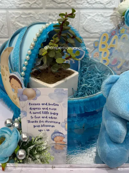 Our baby pram hamper in blue, featuring a cute teddy, a planter, and a personalized card.