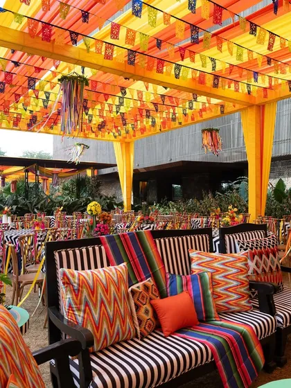 Another view of the lounge seating at the carnival, showing the mix of striped furniture and brightly colored cushions under a festive canopy.