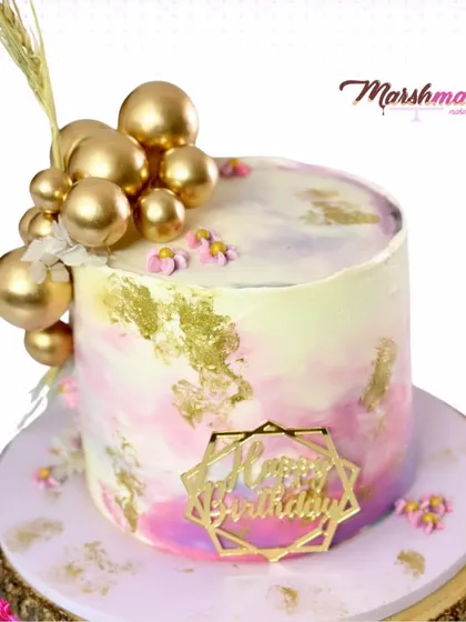 Another shot of the chic watercolour cake, highlighting the beautiful cascade of gold spheres.