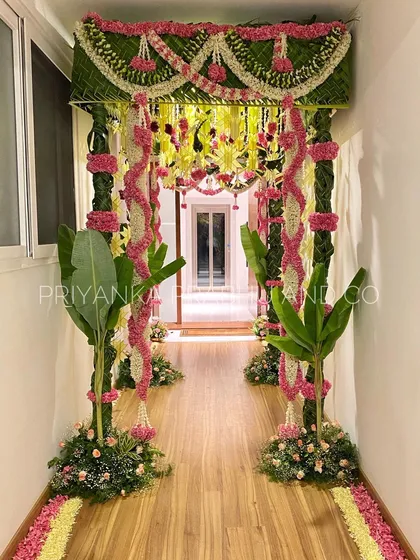 A warm welcome starts at the doorway. I designed this beautiful entrance using traditional elements like banana plants, woven coconut leaves, and garlands of jasmine and roses to create an inviting passage for a pre-wedding celebration.