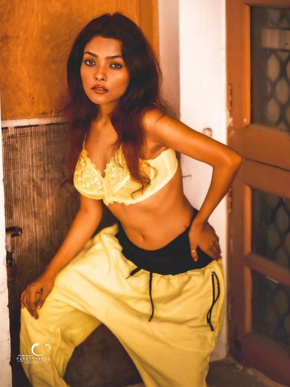 A confident and edgy pose in a rustic doorway. The warm, natural light complements the yellow outfit beautifully.