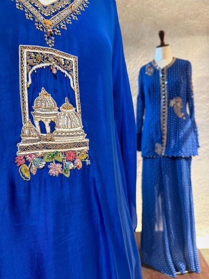A close-up of a royal blue kurta with stunning embroidery depicting a traditional jharokha, a true work of art.