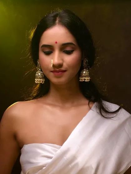 A portrait that captures the essence of traditional beauty with a modern sensibility. The warm lighting and rich tones highlight the intricate details of the jewelry and the subject's serene expression, making it ideal for ethnic fashion or personal branding.