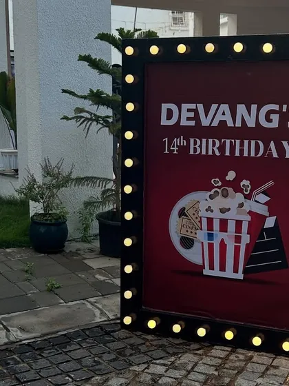 A cinema-style marquee welcome sign for the outdoor movie night birthday party, complete with lights.