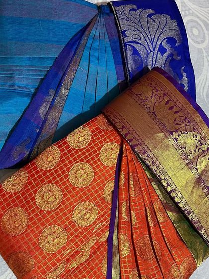 A duo of sarees, one a rich orange Kanjivaram and the other a blue silk cotton, both ready for different events.