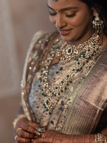 A detailed close-up of the magnificent necklace, showing the intricate setting of the Kundan and emerald stones.