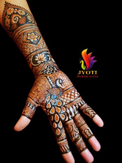 A simple yet beautiful bridal henna design. This piece highlights a peacock on the palm with its feathers flowing down the wrist, surrounded by floral and geometric patterns.