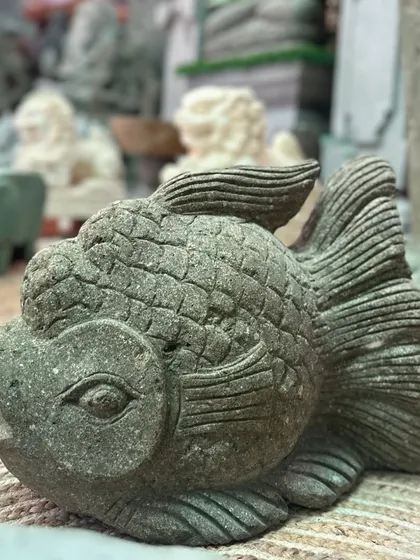 This hand-carved stone fish is a unique accent piece. The textured scales and flowing fins give it a sense of movement, bringing a touch of nature's artistry indoors or out.