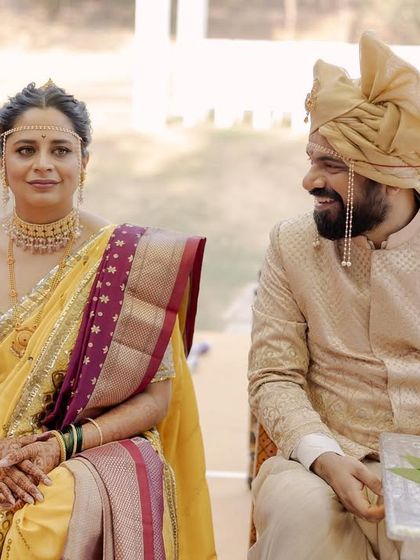 A candid moment between the bride and groom during their temple wedding. The groom's happy glance towards his bride shows the love and joy that underpins the traditional rituals.