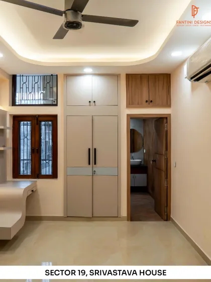 A bedroom from our Srivastava House project, featuring a clean design with built-in wardrobes, a study nook, and a simple yet elegant false ceiling.