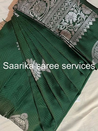 A deep green saree with silver motifs. The pleats are set to create a beautiful fall, making it easy to drape.