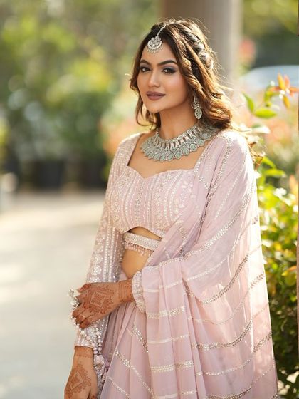 This beautiful pastel pink lehenga is perfectly accented with our delicate silver-finish necklace set, a popular rental for bridesmaids and guests.