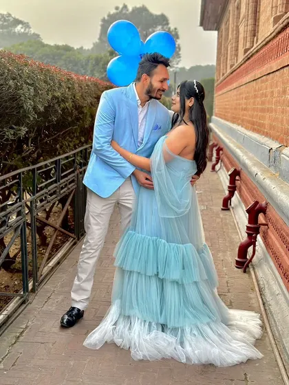 An outdoor shot showing how our Winter gown can be styled for a fun, coordinated couple's look. The blue tones are perfect for a "it's a boy" theme.