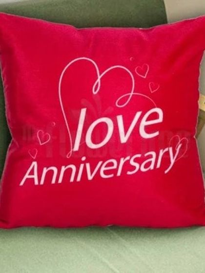 A bright red cushion perfect for celebrating a "Love Anniversary." The simple and elegant script makes it a great decorative piece for a couple's home.