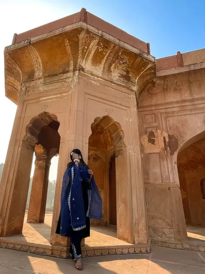 This low-angle shot emphasizes the grandeur of the architectural setting, making the model in her traditional attire look even more majestic.
