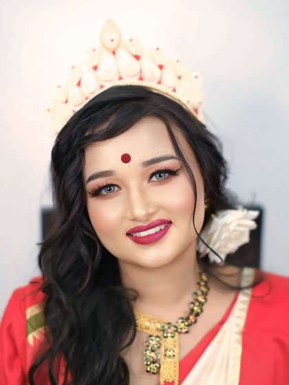 A bright and joyful portrait of a Bengali bride, her smile radiating happiness and her eyes sparkling with excitement.