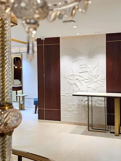 Storytelling is layered into the Talwarsons experience. A hand-carved solid stone mural depicting lotuses grounds the space in artistry and permanence, while a glimpse of a Murano glass chandelier detail hints at the level of craftsmanship throughout.