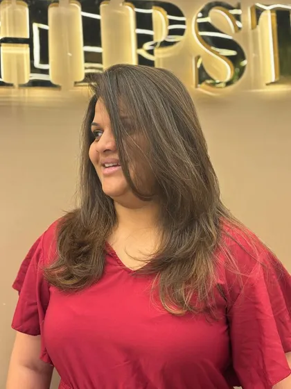 A three-quarter view of a client's new hair color. The soft layers and natural-looking highlights create a beautiful, understated style.