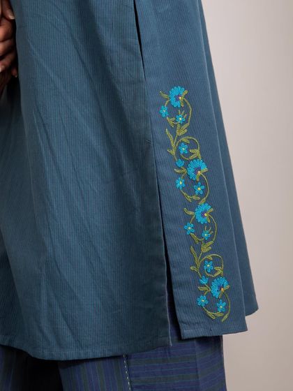 A detail of the Kashmiri crewel floral embroidery on the side slit of our Haveli Blue Kurta. This thoughtful placement adds a touch of artistry to the simple, straight-fit design.