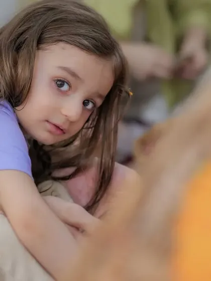 A close-up, candid shot of a child looking towards a loved one. This perspective creates an intimate and emotional portrait, making you feel like you are right there in the moment.