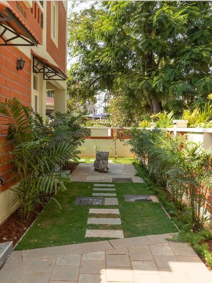 A landscaped walkway along the side of the house, demonstrating how even narrow spaces can be turned into green corridors that enhance the living experience.