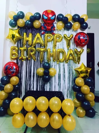 A simple and fun Spider-Man theme with foil character balloons, a "Happy Birthday" foil banner, and columns of black and gold balloons.