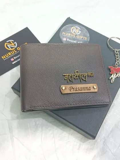 A personalized genuine leather wallet in a textured brown finish, featuring a 'Mahakal' charm and a nameplate, shown with a complimentary 'I love you' keychain.