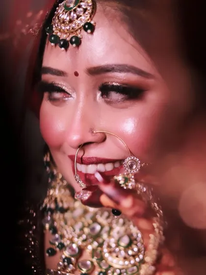 A beautiful, happy smile from the bride. This close-up shot captures the joy of the moment and the perfection of her glittery eye makeup and bold lip.