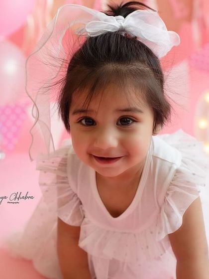 Pretty in pink! A close-up of one of the adorable twin sisters from their first birthday shoot, her sweet smile is just heart-melting.
