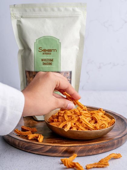 A hand reaches for a Soya Stick from a bowl, with the convenient resealable bag in the background. It's a snack shelf staple for any time cravings.